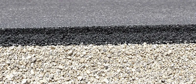 Saw cut road edge showing stacked asphalt layers over a limerock base
