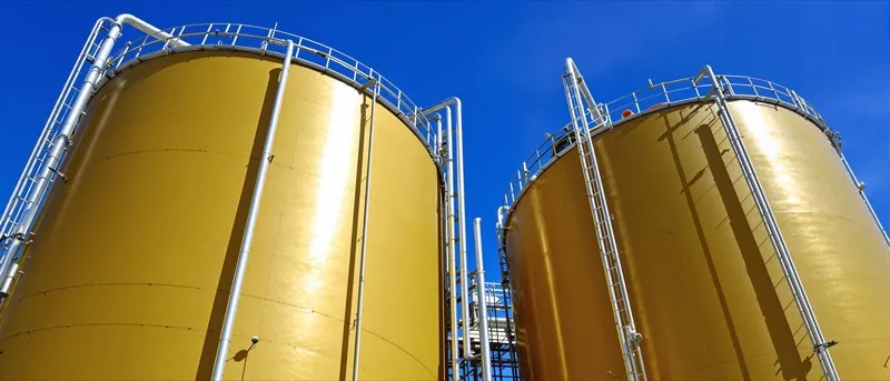 Insulated asphalt binder storage tanks and piping under midday Florida sun